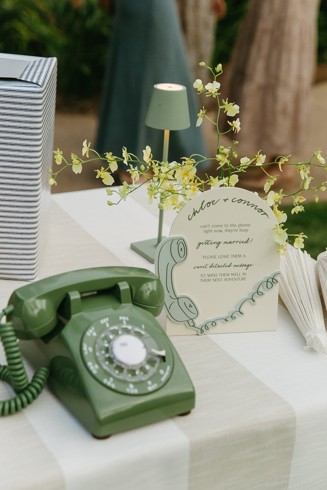 Green rotary telephone and instructional sign on a wedding guest book table.