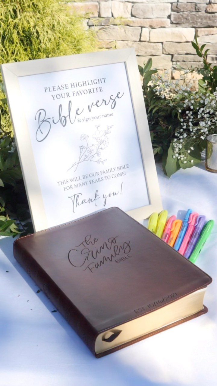 Leather-bound family Bible with a framed instruction sign and colorful highlighters on table