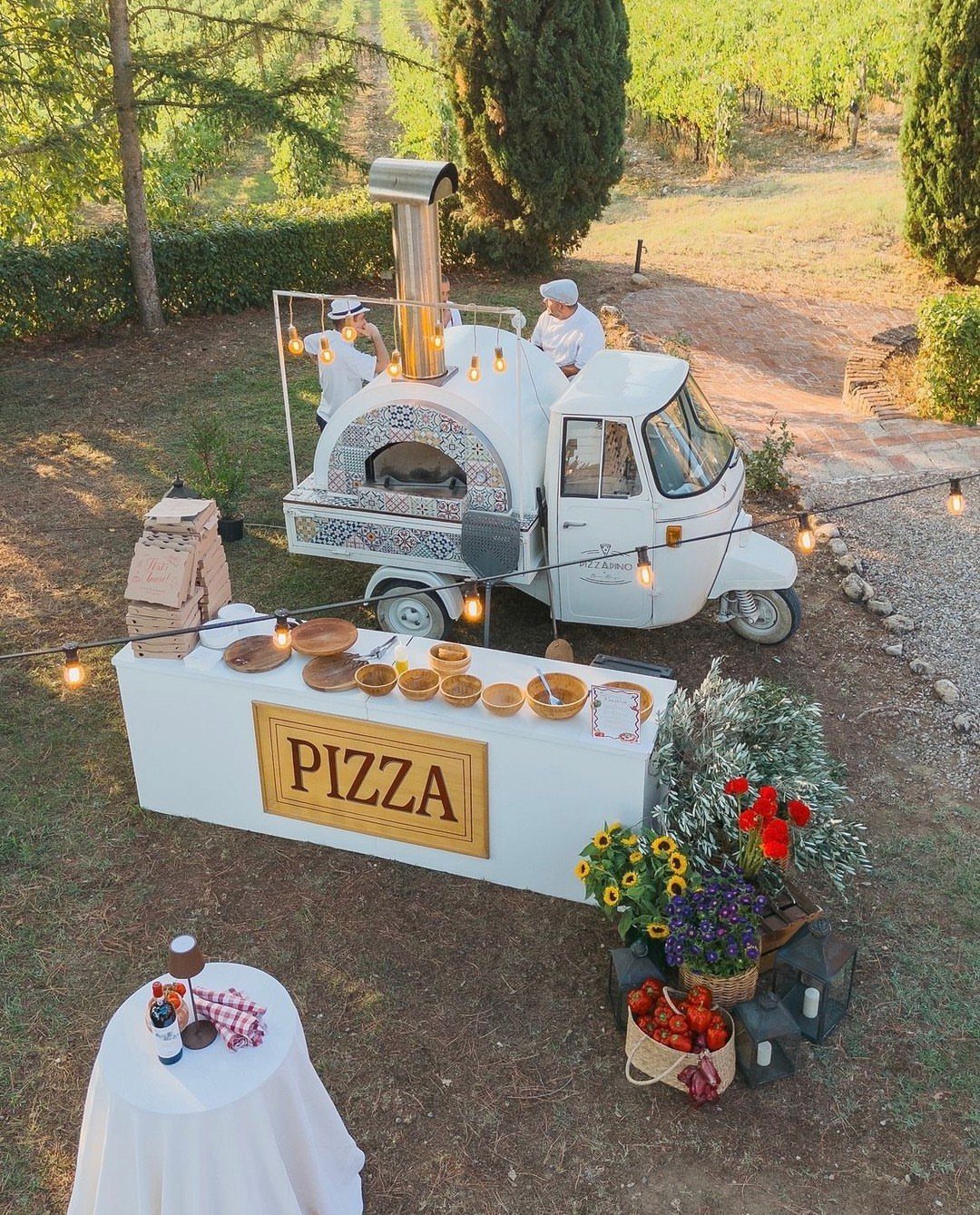 White vintage pizza food truck with chefs serving at an outdoor vineyard wedding