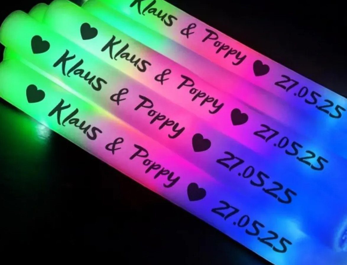 Neon glow sticks with personalized wedding names and date on a black background