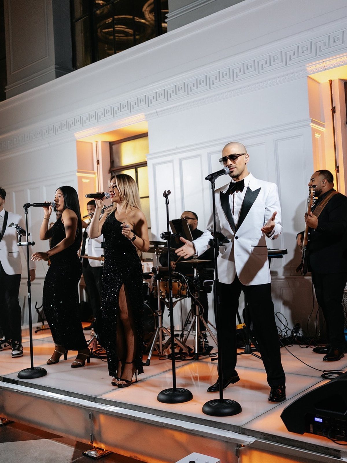 Live band with singers and musicians performing on a stage at an event