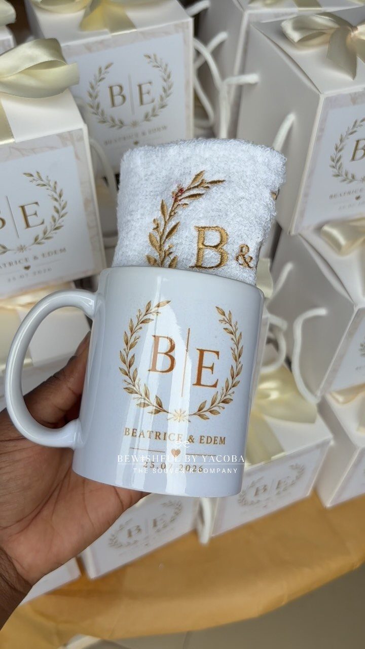 White ceramic mug with gold personalized wedding initials and names held by hand.