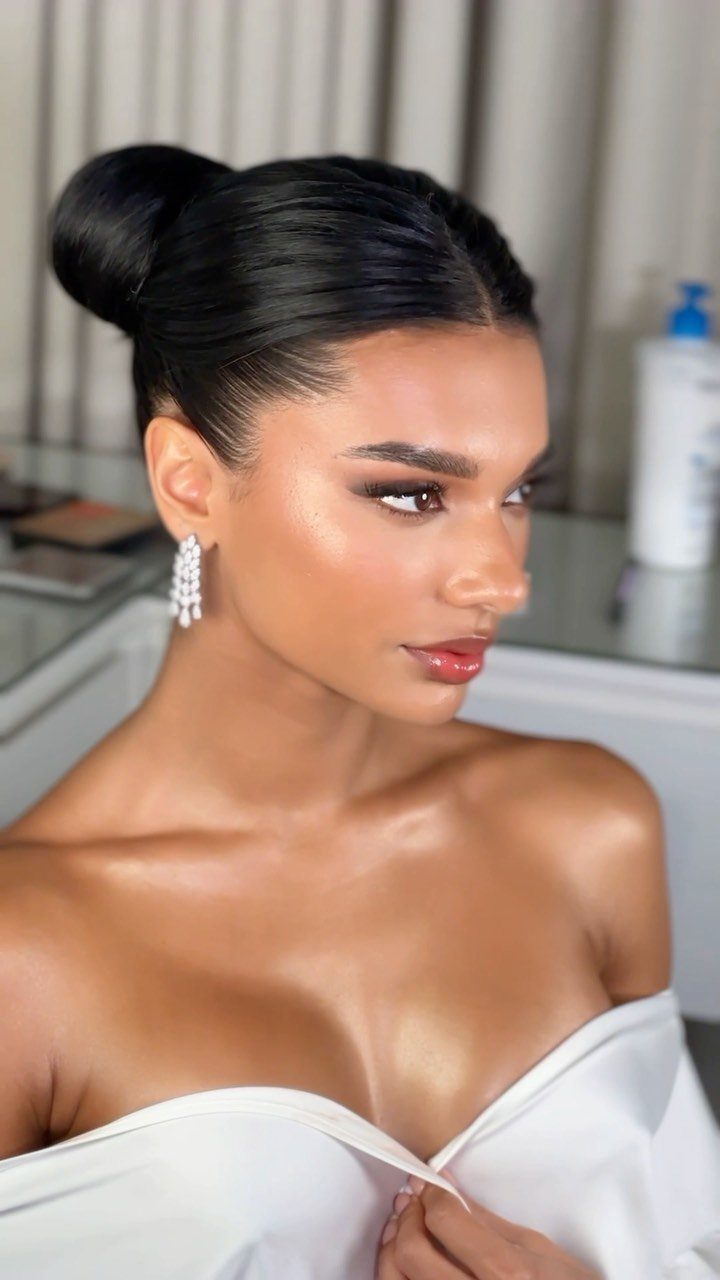 Woman with a sleek high ballerina bun and white off-the-shoulder dress