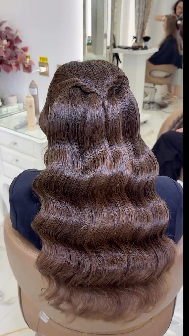 Long brown hair styled in structured Hollywood waves from a back view