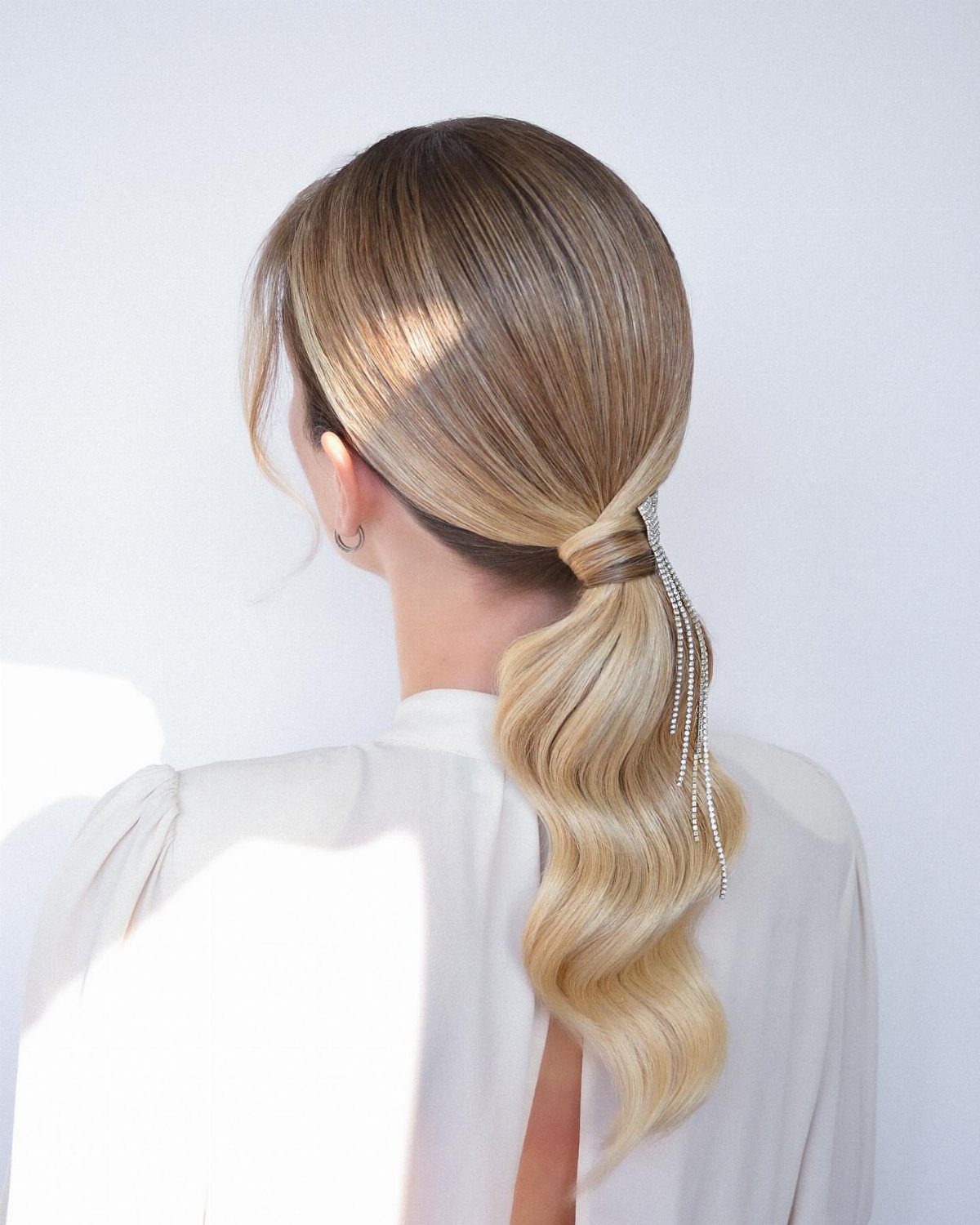 Blonde woman with a low wavy ponytail and silver beaded hair accessory
