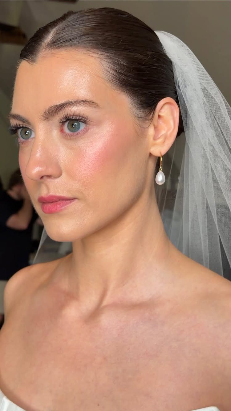 Woman with blue eyes wearing a bridal veil and natural wedding makeup.