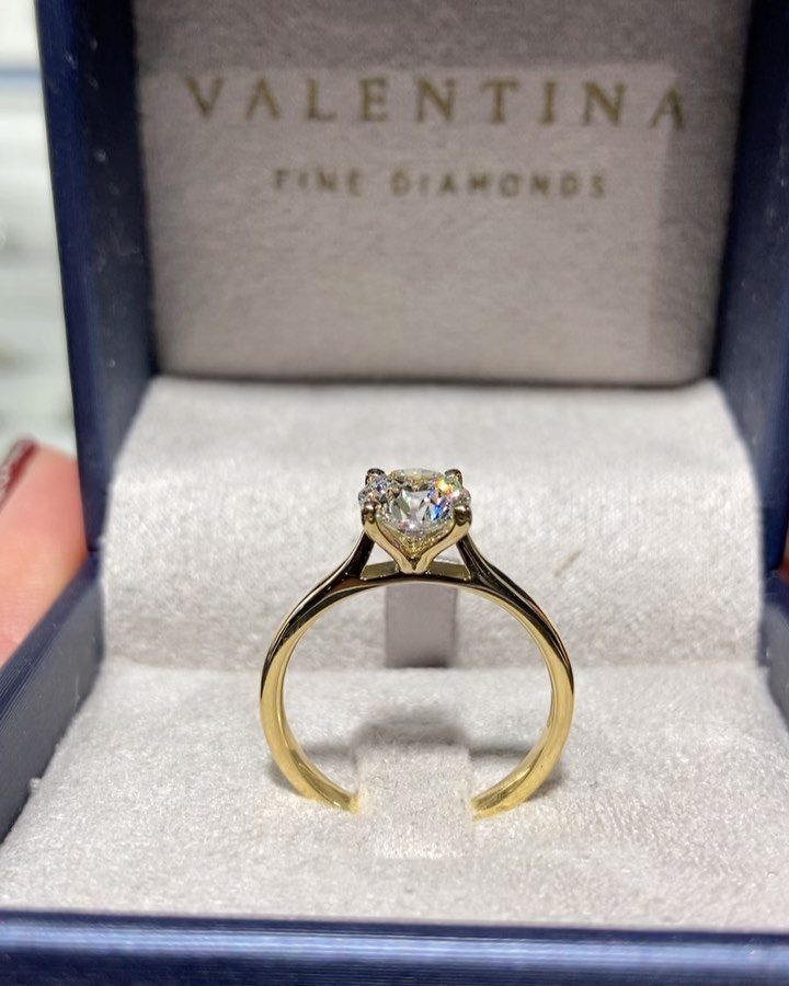 Gold diamond engagement ring resting in a blue Valentina Fine Diamonds jewelry box