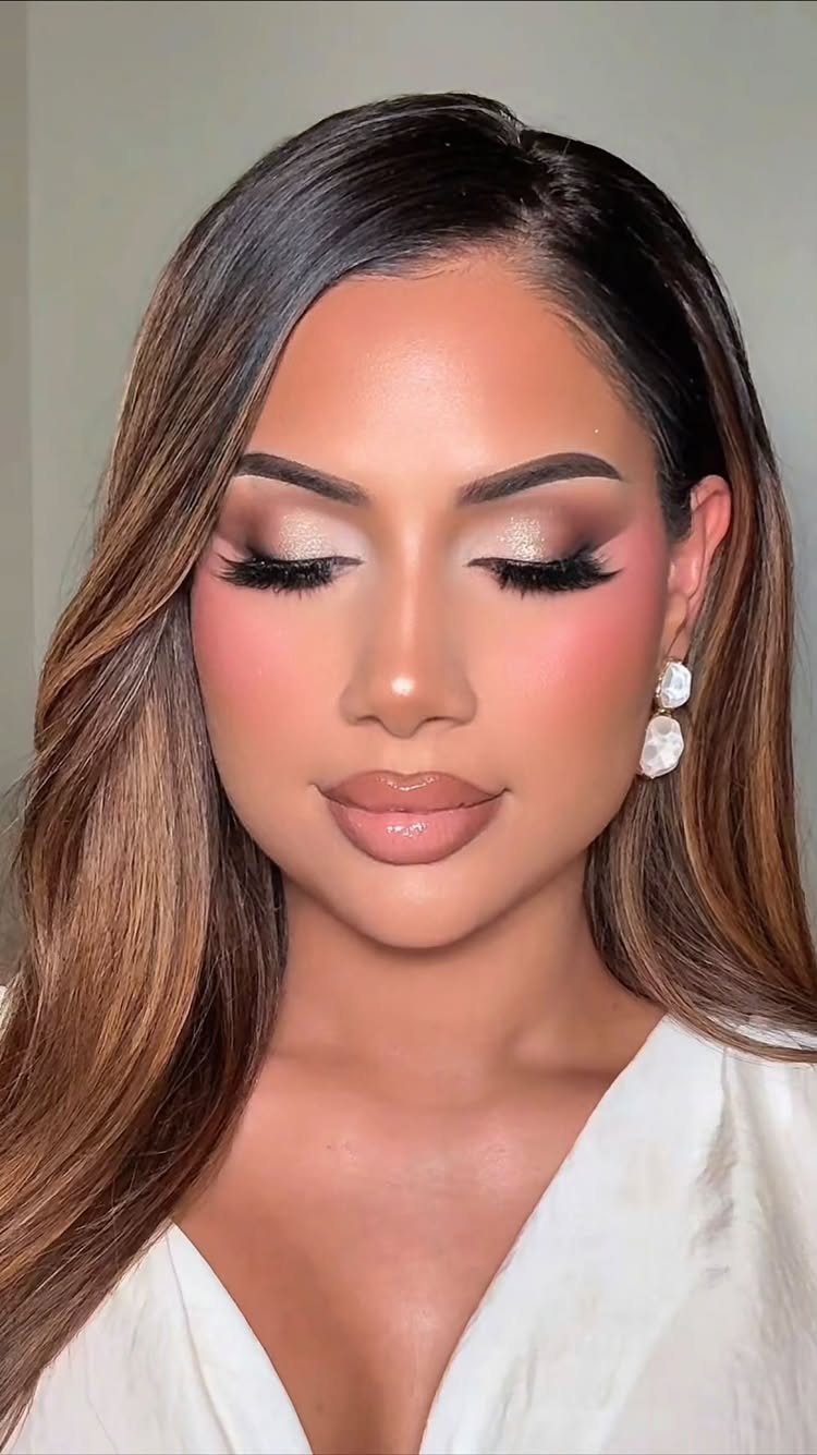Woman with champagne eyeshadow, nude lips, and soft glam bridal makeup posing.