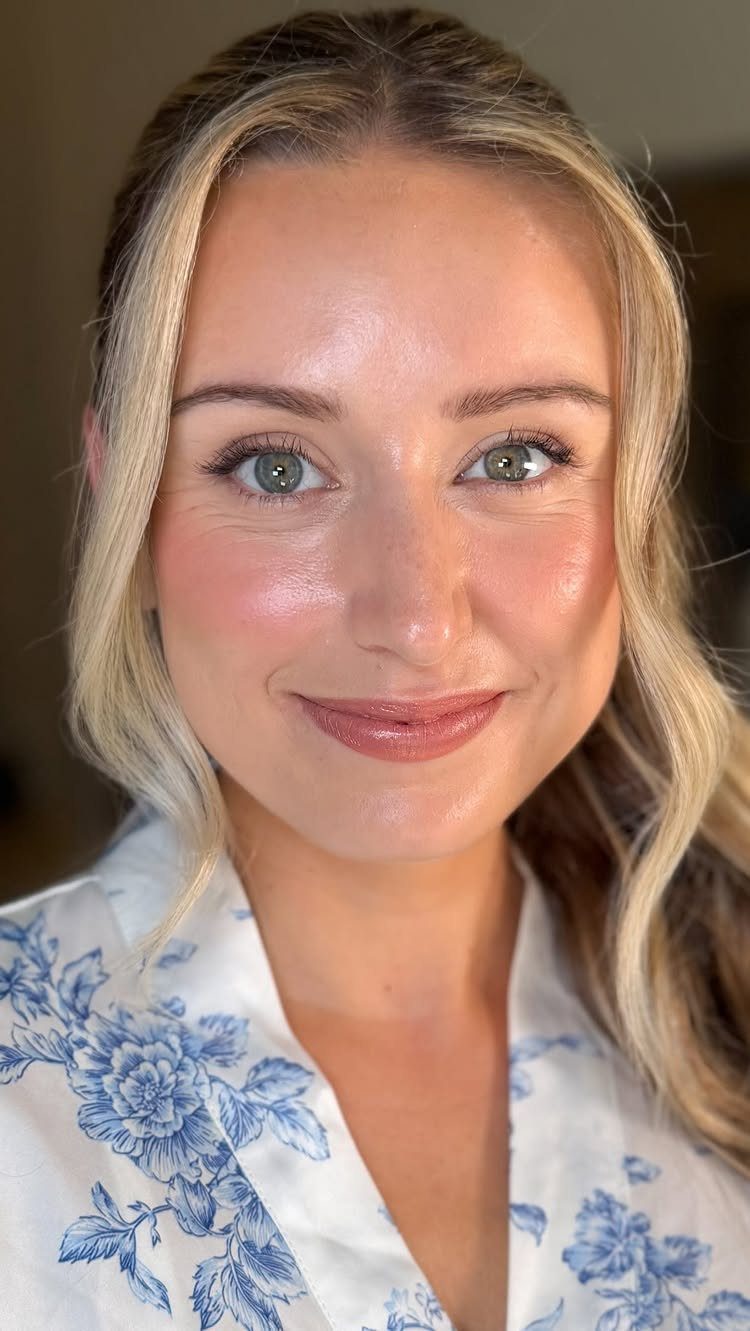 Woman with soft glam bridal makeup and nude lips wearing a floral robe.