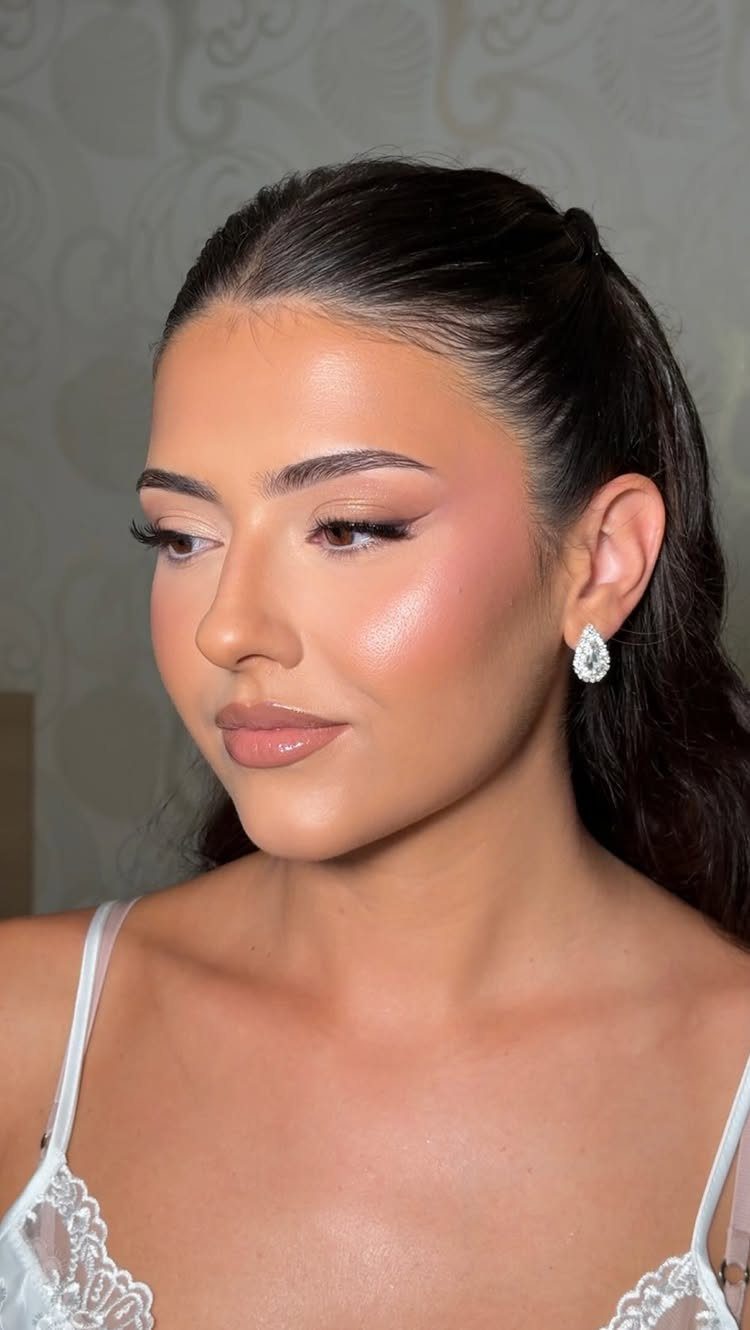 Woman with soft glam makeup, neutral tones, and white lace wedding attire.